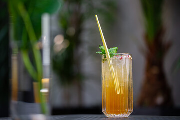 Glass with orange mojito cocktail with lemon and mint, cold refreshing drink or beverage with ice on bright background. Overhead view, copy space. Advertising for cafe menu