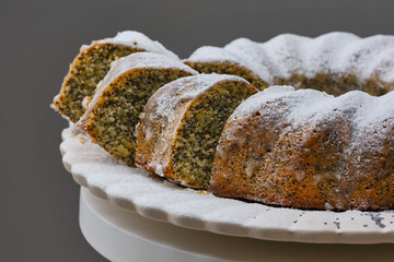 Sliced Bundt or Muffin cake with poppy seeds decorated icing sugar. Kozunak in to Romania and Bulgaria. Christmas Stollen traditional German, European Festive Dessert. Shallow depth of field