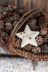 Rustic Christmas Deco With Pine Cones And Star With German Text For Merry Christmas