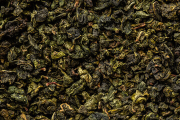 Heap of dry tea leaves. Dried green tea. Textured background of dried leaves of aromatic tea.