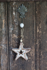 Rustic Christmas Star Ornament Hanging Across Wood