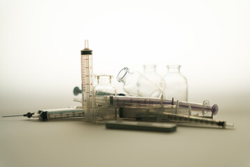 Vials of medicine and silhouette plastic syringe with needle. needle phobia. Traditional method for medicine injection with syringe. Vintage image tone pile of syringe in silhouette.