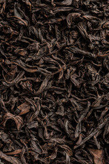 Heap of dry tea leaves. Dried black tea. Textured background of dried leaves of aromatic black tea...