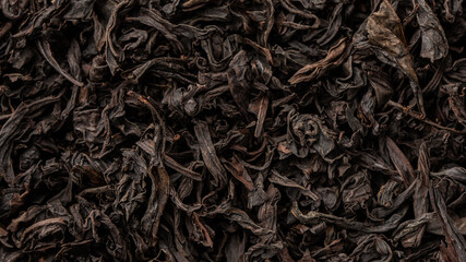 Heap of dry tea leaves. Dried black tea. Textured background of dried leaves of aromatic black tea...