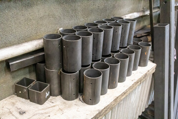 Round pipes are cut into short pieces and stacked neatly in a locksmith's shop.