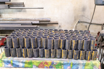 Round pipes are cut into short pieces and stacked neatly in a locksmith's shop.