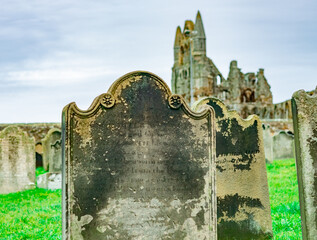 Close and selective focus on an old headstone, dating back to the 1800s, in a graveyard with the...