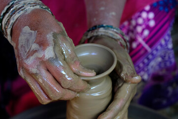 Pune, India- 22 October 2021: Indian Potter lady At Work making diyas from Clay during diwali festival, Artistic beautiful clay lamp made by potter.