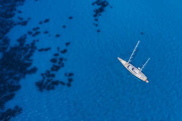 Fototapeta premium Lefkada, Greece. Remote white Egremni beach with lonely luxury yacht boat on the turquoise colored bay on Ionian Sea