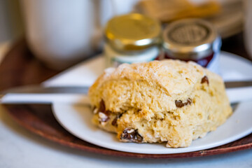  A traditional afternoon cream tea with close and selective focus on the scone