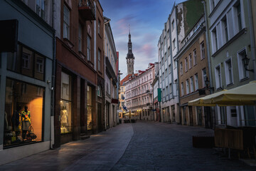 Tallinn old town Viru Street at sunset with Tallinn Town Hall Tower on background - Tallinn, Estonia