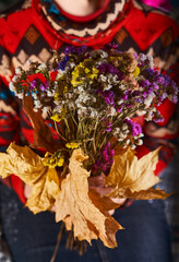 Dry bouquet of flowers in the woman's hands