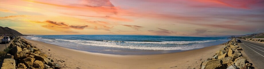 a stunning panoramic shot of the vast blue ocean at the beach with smooth silky brown sand and...