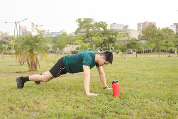 Young man doing push-ups in the square.