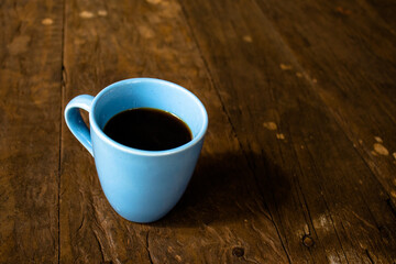 Blue Coffee Mug on Rustic Wooden Table with Hot Coffee
