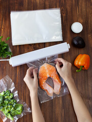 The process of packing a piece of fresh red fish into a vacuum bag and sealing