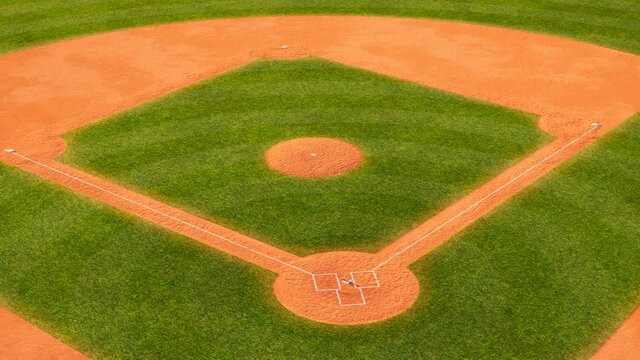 Huge green baseball field. Sport stadium with grass and orange field with sand.