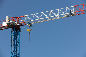 Naklejka premium blue, white and red construction crane against the sky