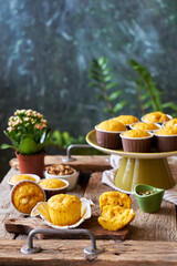 Pumpkin muffins with white chocolate and walnuts. Side view, wooden and green background.