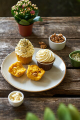Pumpkin cupcake with white chocolate and walnuts. Side view, wooden background.