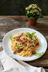 Spaghetti with bolognese sauce and basil. Side view, wooden background.