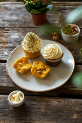 Pumpkin cupcake with white chocolate and walnuts. Side view, wooden background.