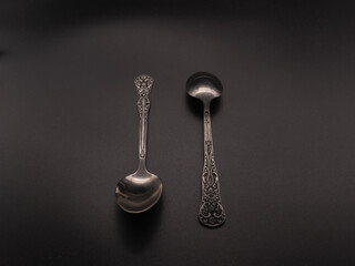 Two teaspoons on a dark background. Subject shooting