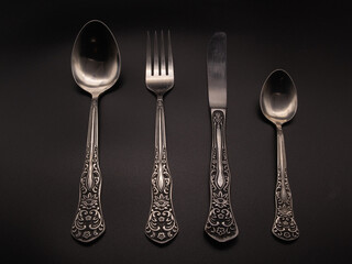 Spoon, knife, fork on a dark background