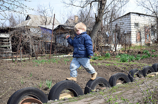 Little boy jumping on tires.