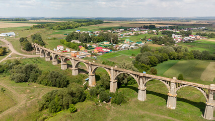 an old abandoned railway bridge with arches shooting from a drone