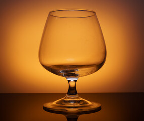 transparent glass goblet on yellow background