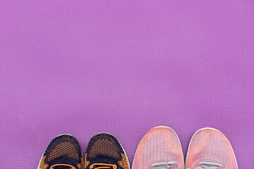 Sneakers and a purple fitness mat. Sport concept