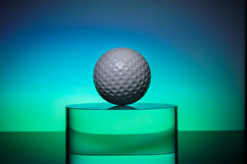 white golf ball on the transparent glass on color background