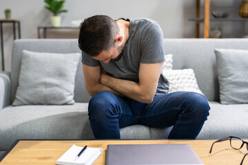 Man Suffering From Stomach Ache Sitting