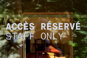 Accès reservé. Staff Only. Inscriptton sur une porte vitrée.