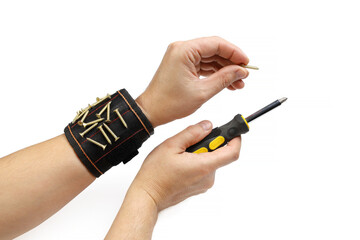 Tools magnetic bracelet on wrist with screws and screwdriver in person hands, close-up isolated on...