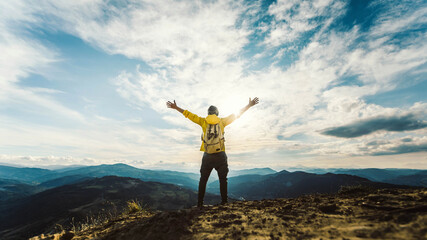 Man traveler on mountain summit enjoying nature view with hands raised over clouds - Sport, travel business and success, leadership and achievement concept - obrazy, fototapety, plakaty