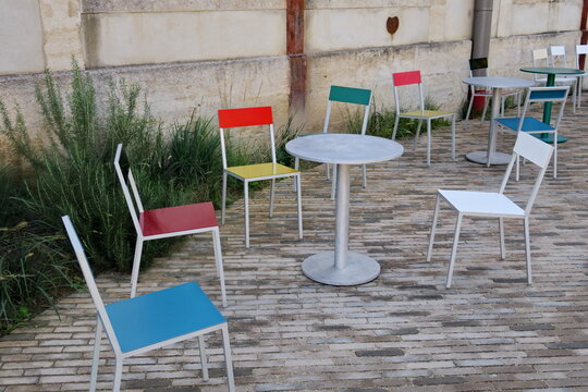 Terrasse de café avec chaises colorées.