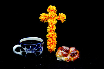Obraz premium Hot coffee in an artisan cup with fluffy and delicious bread of the dead with sesame in offering of the Day of the Dead with decoration of cempasuchil and colored cut-out paper and candles 