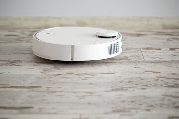 white robotic vacuum cleaner. The robot is controlled by voice commands for direct cleaning. Modern technology of smart cleaning.