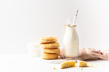 Freshly baked homemade honey cookies with milk for breakfast on a white background