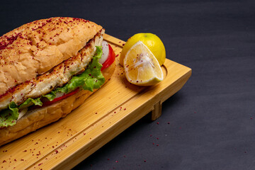 Turkish food sandwich balik Ekmek with grilled mackerel, tomatoes, onions and lettuce served with...