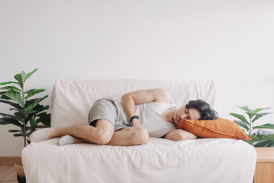 Weird and funny sleep pose of Asian man in his apartment in boring day off.