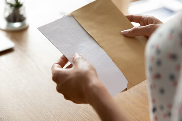 Hands of woman receiving letter, invitation, notification, postcard, taking out document for...