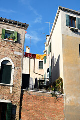 Washing lines in an alley in Venice, Italy. Laundry hanging on a clothes line between city buildings. Clothes lines between old brick houses.