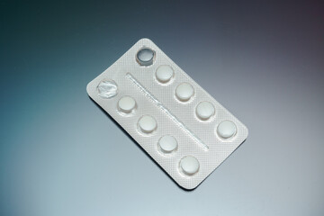 medical blister pack with white pills on background