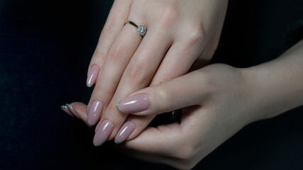 Womans hands with nude beige pink nail design. Manicure, fashion and beauty salon concept