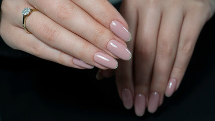Womans hands with nude beige pink nail design. Manicure, fashion and beauty salon concept