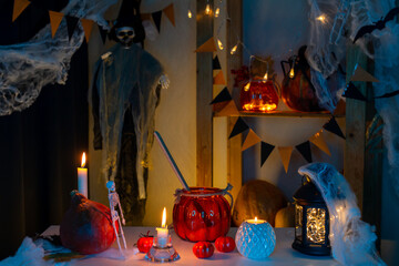Halloween atmosphere in the dark. There were a pumpkin and candles on the table. Skeleton of a witch