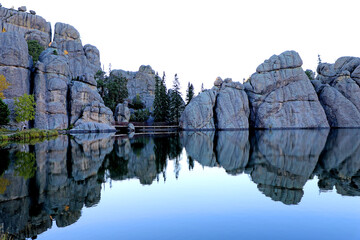 Sylvan Lake's Rocks, Trees, and Bridge Are Reflecting On The Water